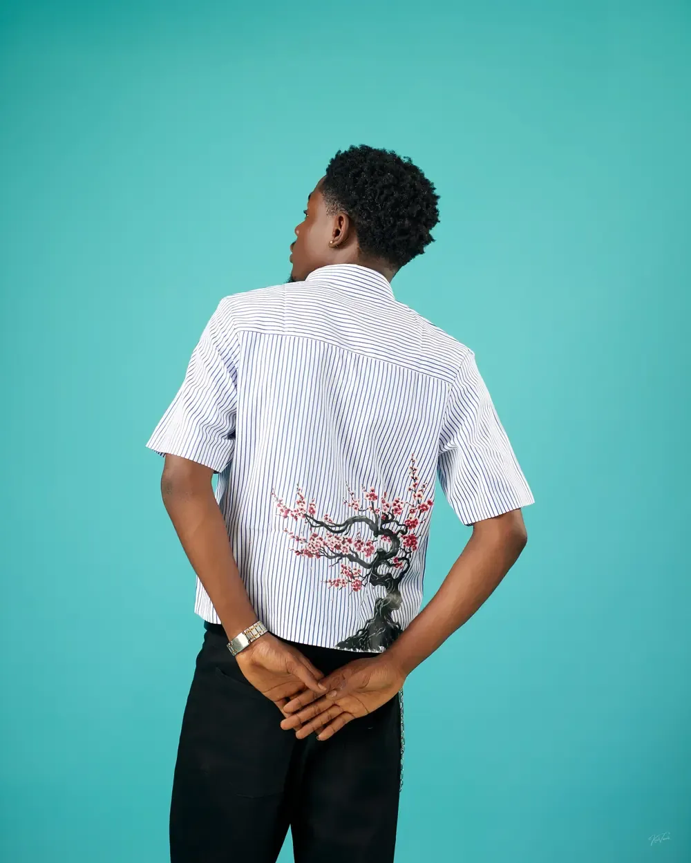 Back view of the Blossom Stripe Shirt in Blue + White with a cherry blossom tree on the lower back