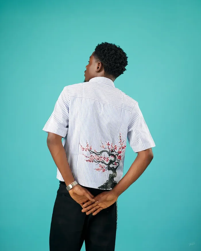 Back view of the Blossom Stripe Shirt in Blue + White with a cherry blossom tree on the lower back