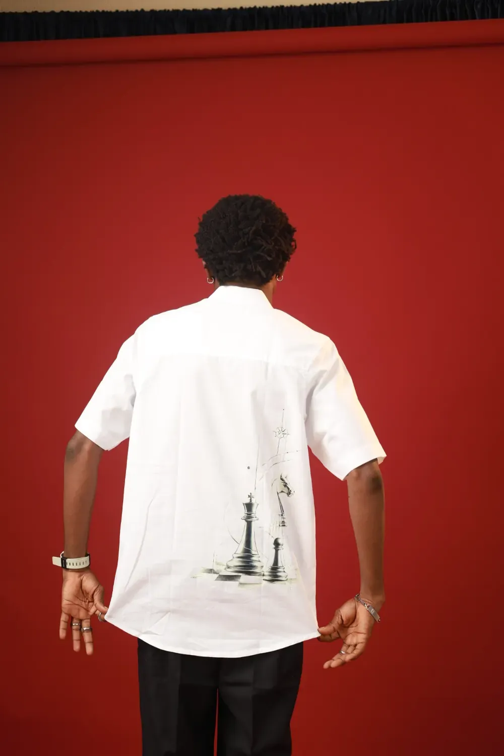 Back view of the white Chess & Eye Monogram Shirt with a king, knight and pawn print on the lower back