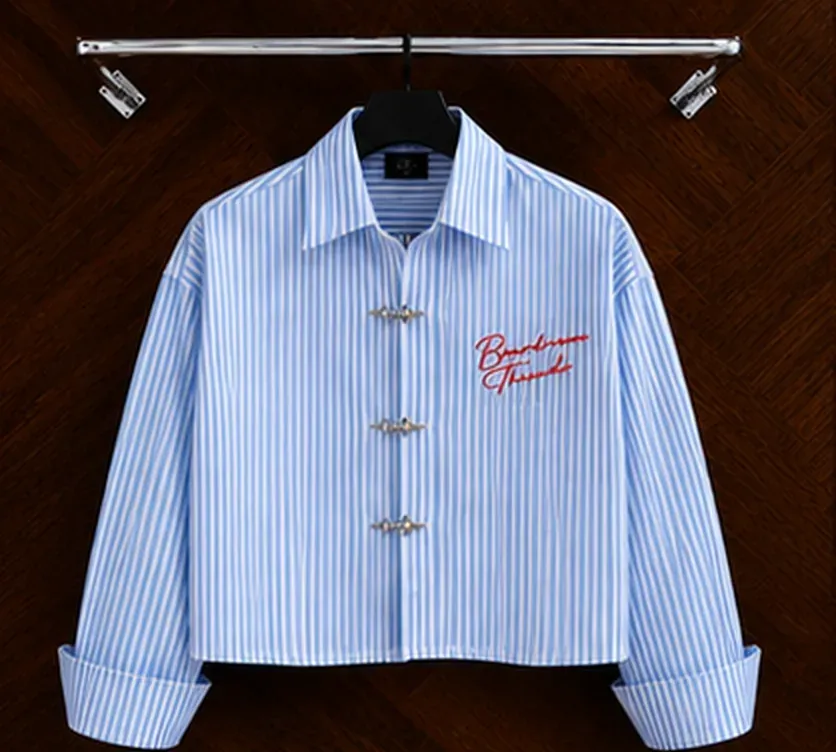 The Clasp Shirt in Sky Blue + White, hanging on a rail